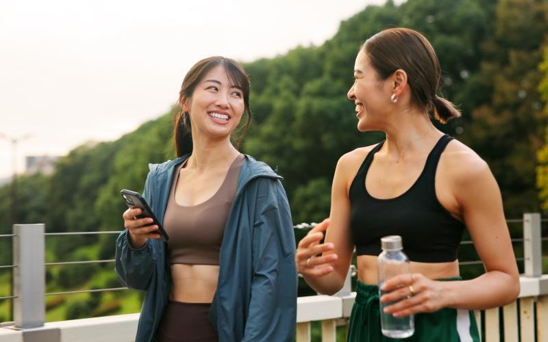 a couple of women smiling and holding bottles of water